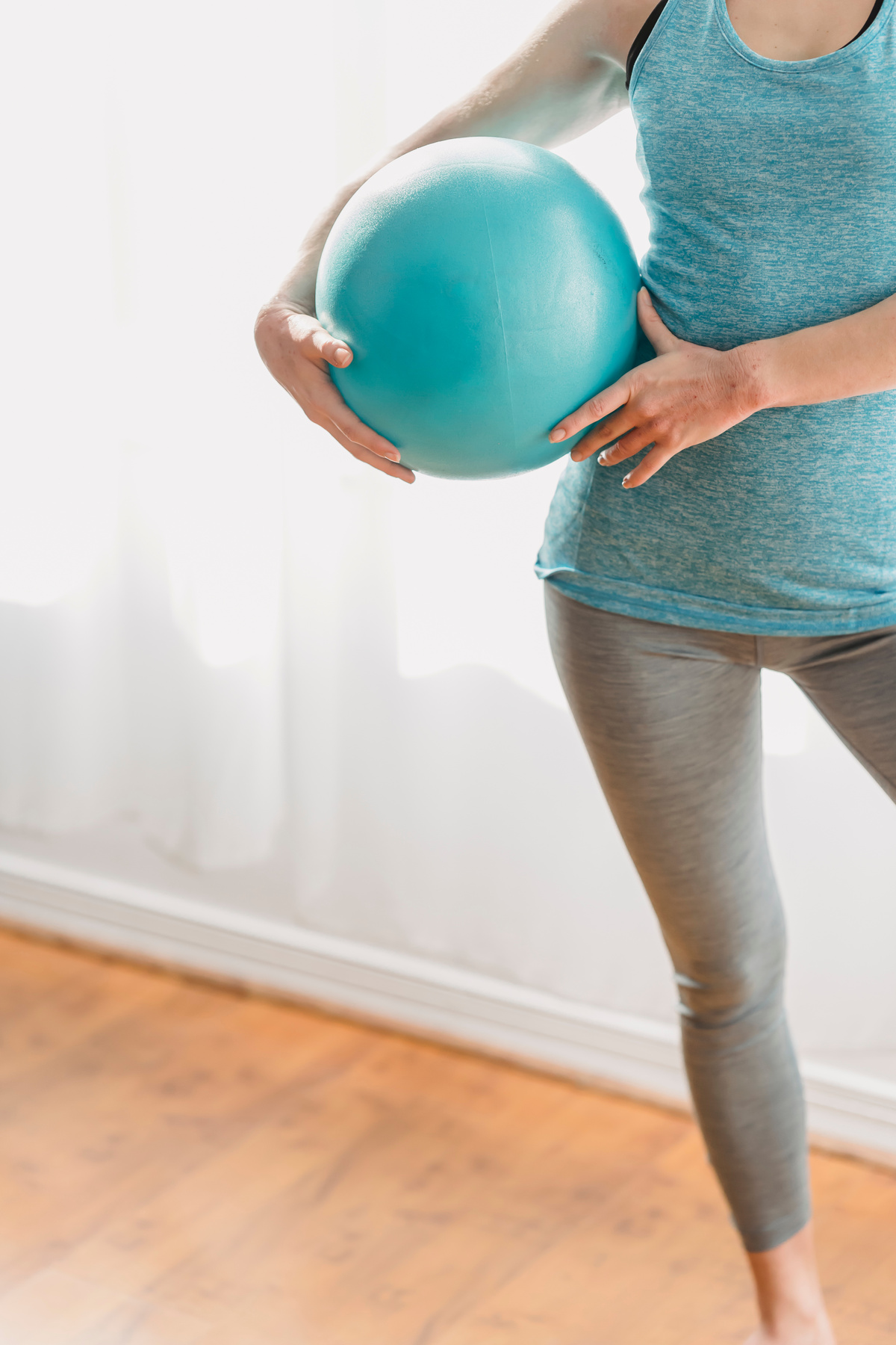 Woman with fit ball in light gym